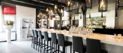 Sip crafted cocktails at the sleek bar beneath warm lanterns.