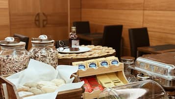 A buffet with labeled containers of mixed bread, cheese, and various spreads.