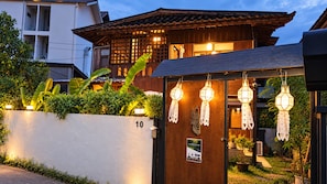 A traditional wooden house with a number 10 sign, a wooden gate, and decorative hanging lanterns. - Charming Home Chiang Mai (Chiang Mai)