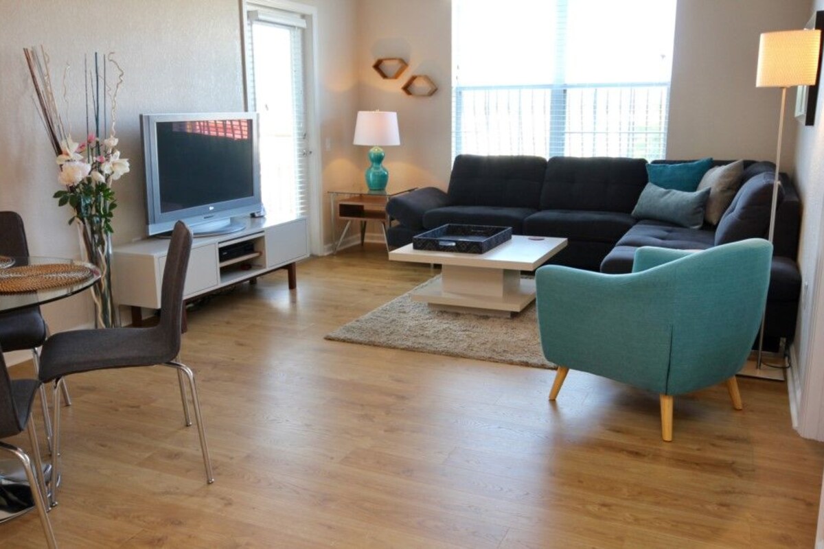 Ein Wohnzimmer mit Fernseher, Sofa, Couchtisch und Sesseln.