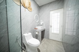 A modern bathroom with a toilet, sink, and shower area.