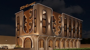 Un edificio moderno con un diseño arquitectónico único, con amplias ventanas y un cartel llamativo.