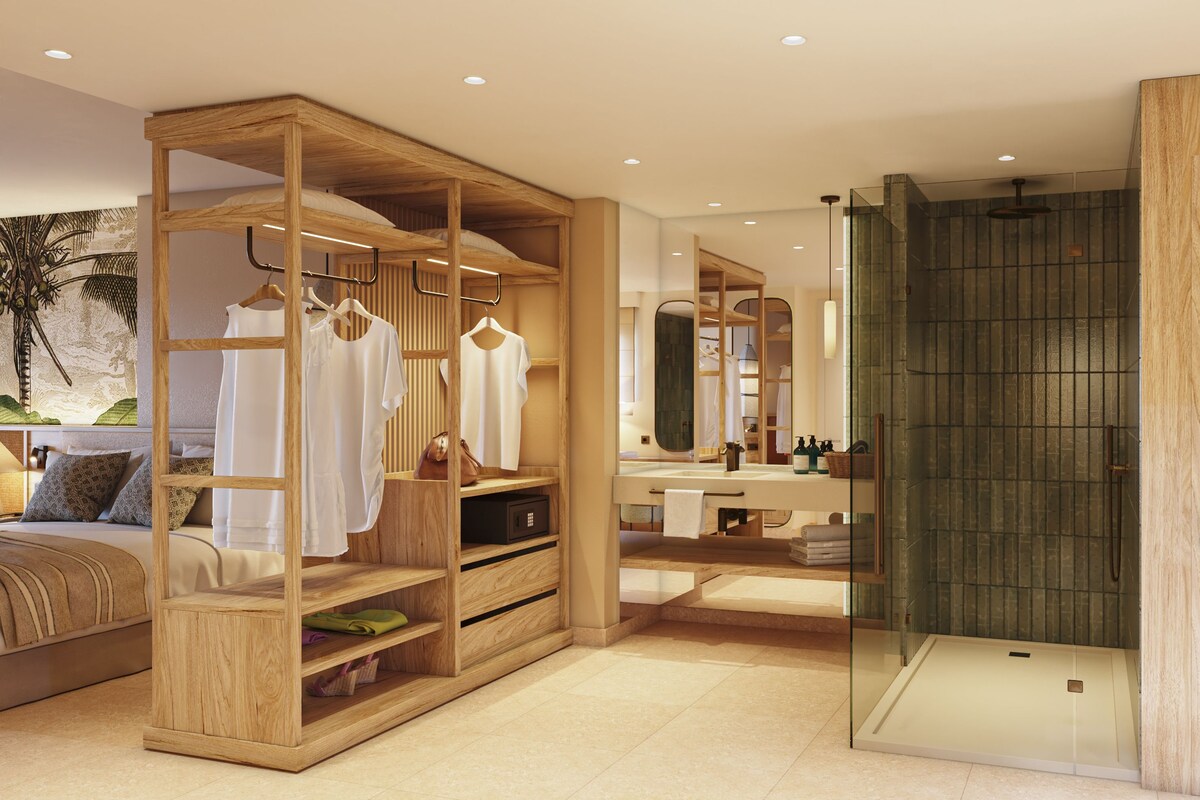 Un baño moderno con tocador de madera, cabina de ducha de vidrio y un espejo grande.