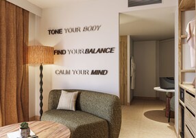 Una habitación moderna con sofá, lámpara y decoración mural inspiradora.