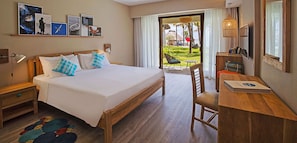 A hotel room with a large bed, wooden furniture, a desk, and a view of the outdoors. - C Mauritius (Belle Mare)