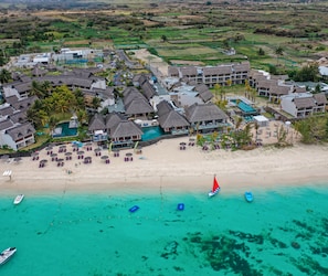 A resort with multiple overwater bungalows, a beach, and a swimming pool. - C Mauritius (Belle Mare)