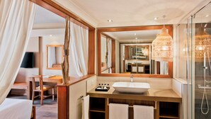 Un bagno moderno con un ampio specchio, un mobile bagno in legno e un box doccia in vetro.