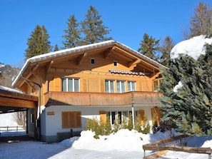 Un chalet in legno con un balcone, un cartello con la scritta 'APOLLO' e neve tutt'intorno alla struttura.