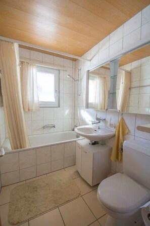 Un bagno con vasca, lavandino, WC e doccia.