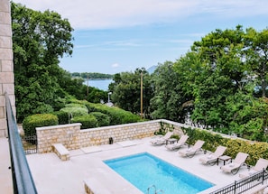 A rooftop pool with lounge chairs and a view of a body of water and trees. - Villa Franica (Dubrovnik)