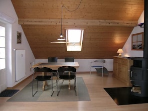 A cozy kitchen with a wooden ceiling, a dining table with chairs, a window, and a stove. - Pierenhus Appartement/Fewo, Dusche, WC, Balkon 2-Zimmerwohnung by Interhome (Adelboden)