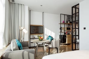 Een moderne hotelkamer met een eethoek, een zithoek en een keuken.