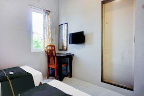 A room with two beds, a desk with a chair, a television, and a window with curtains. - Collection O Banda Aceh Near Masjid R Baiturrahman (Banda Aceh)