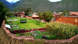 A rural village with terraced fields, a playground, and traditional buildings. - Boutique Lizzy Wasi Hotel (Urubamba)