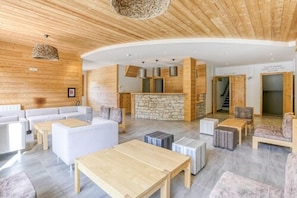 A modern interior with a stone accent wall, wooden ceiling, and a curved layout.