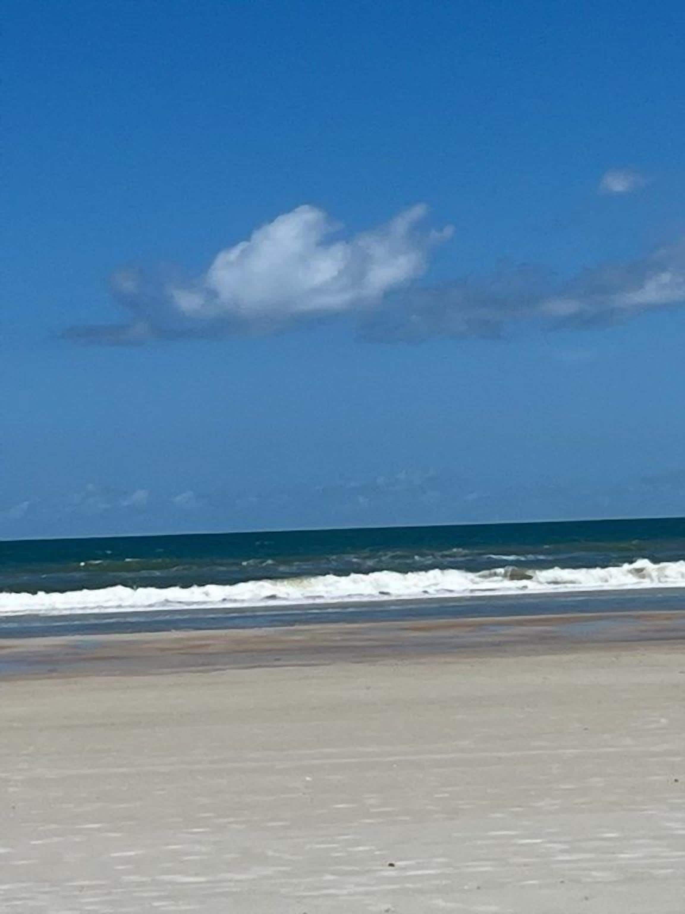 A beach with a clear sky and ocean waves.