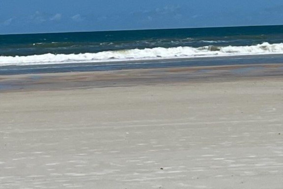 A beach with a clear sky and ocean waves.