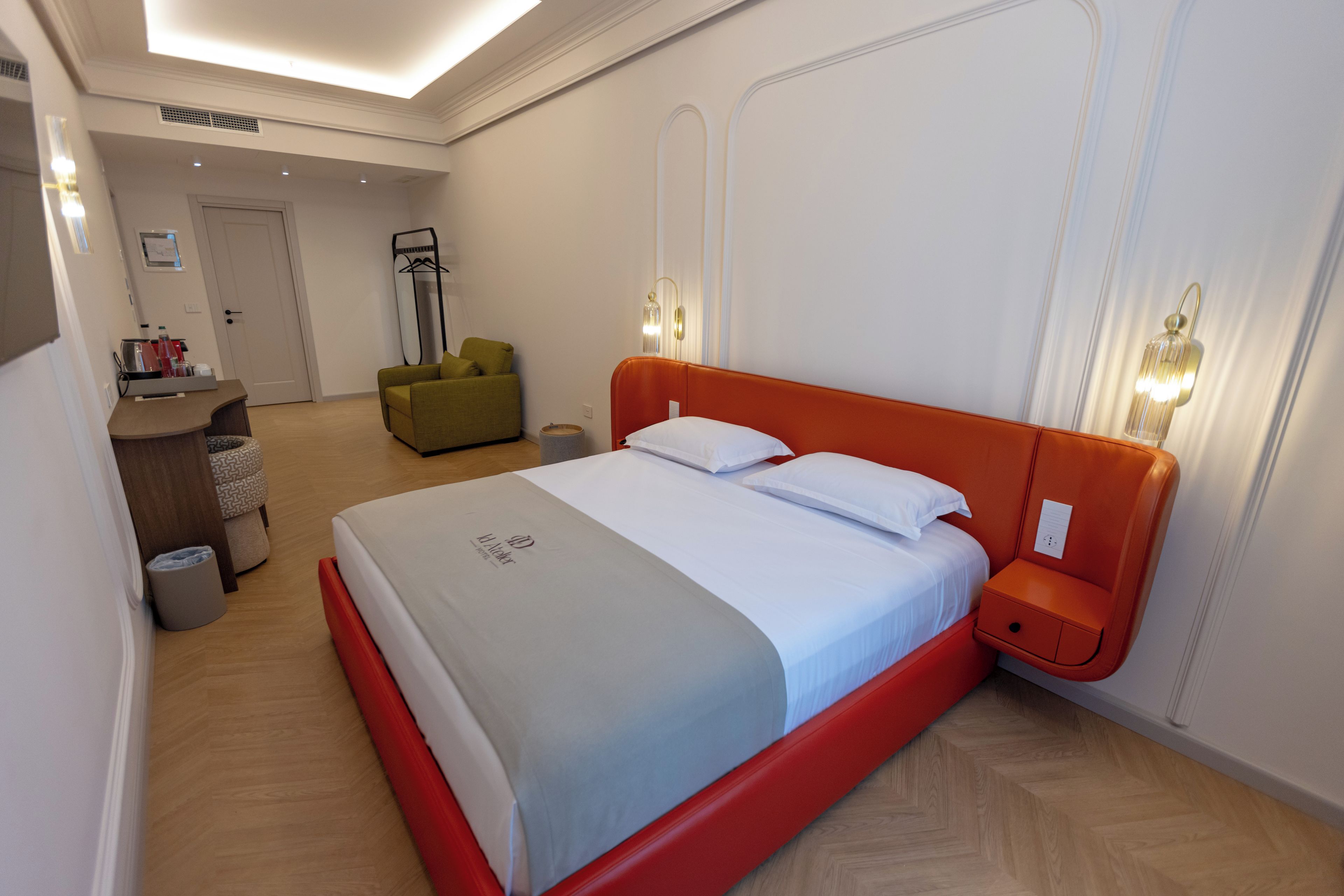 Ein Hotelzimmer mit einem Bett, einem Nachttisch und einer Sitzecke mit einem Sessel.