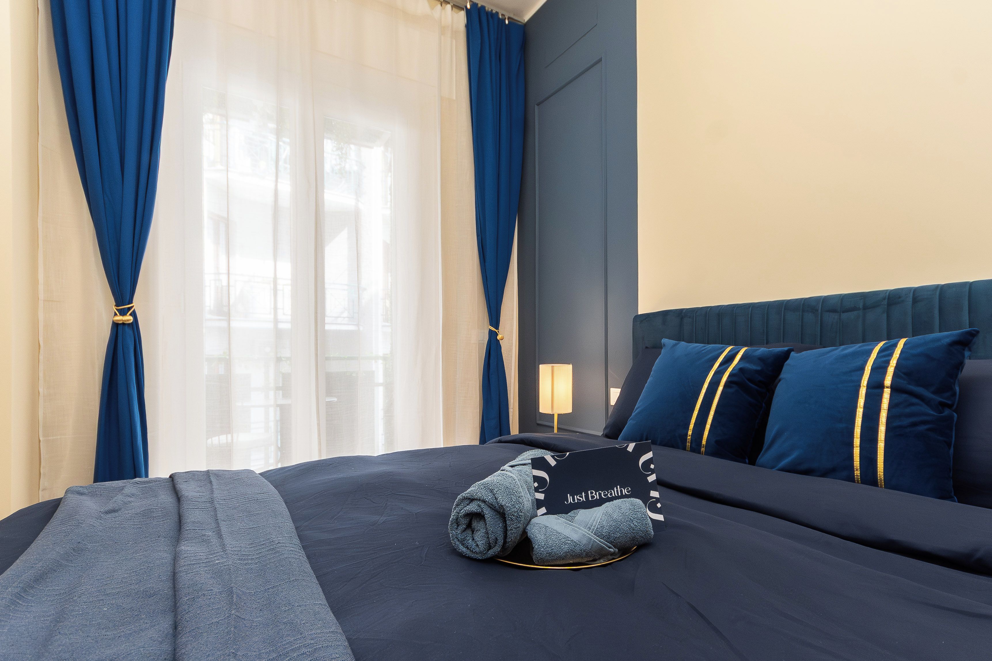 Une chambre d’hôtel avec un lit, un oreiller, une couverture et une fenêtre avec des rideaux.