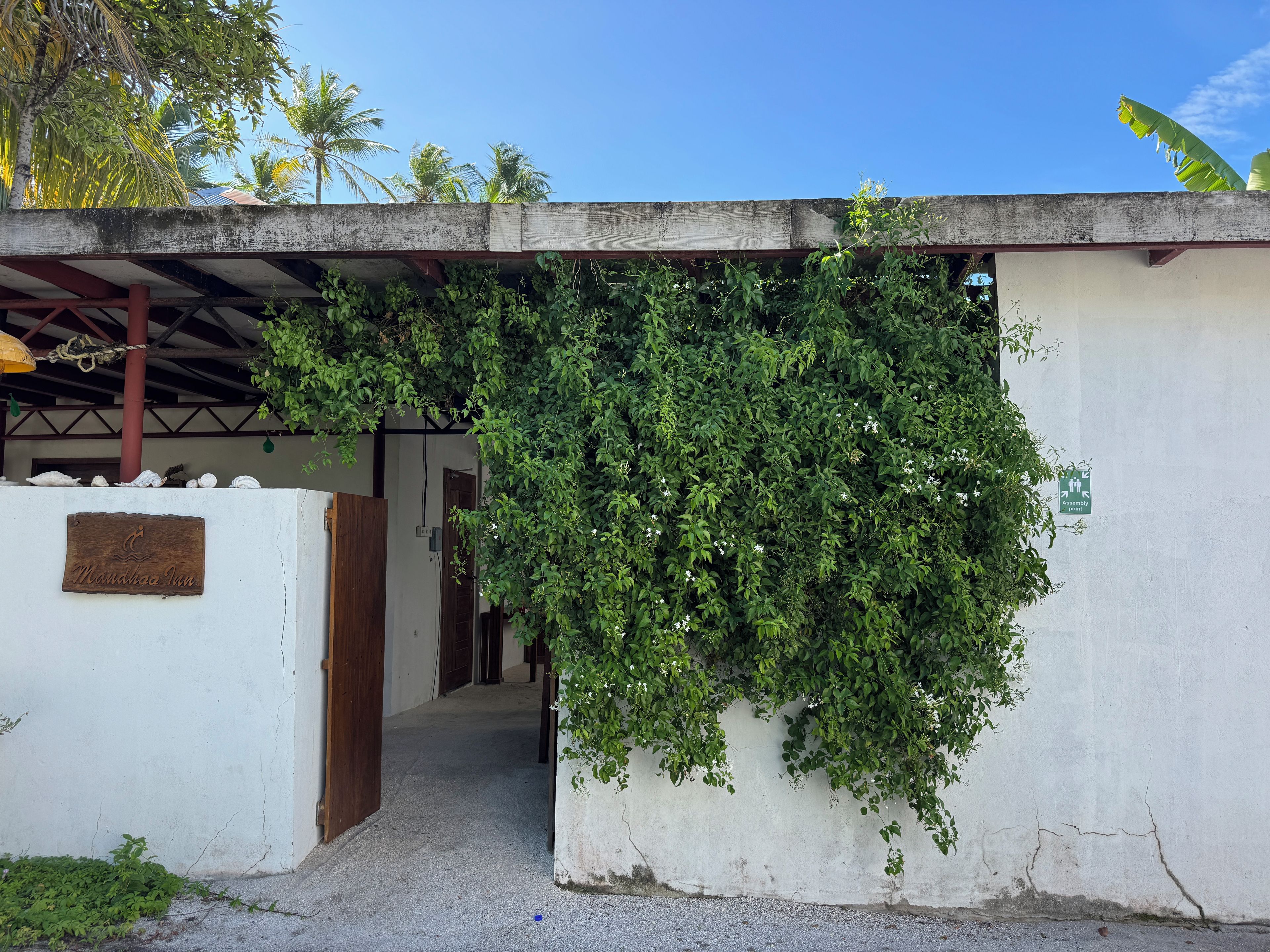 A building entrance with a sign reading 'Maundhaa Inn' and a green sign indicating an assembly point.