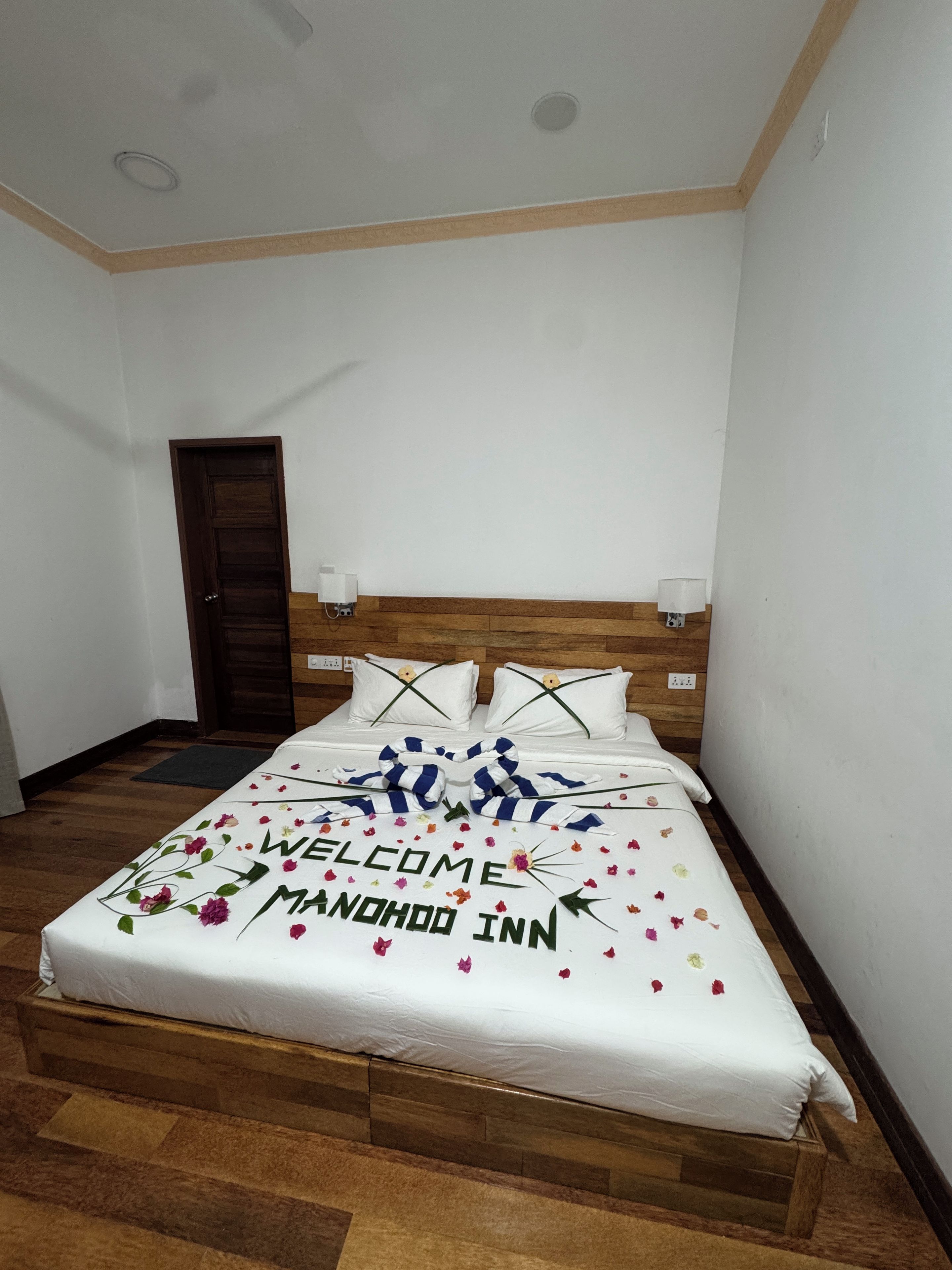 A neatly made bed with a welcome mat and a message on the bedspread.