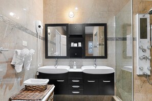 A modern bathroom with two sinks, a large mirror, and a shower area. - Hospitality Expert VSV BF 3BR Chef Pool  (Montego Bay)
