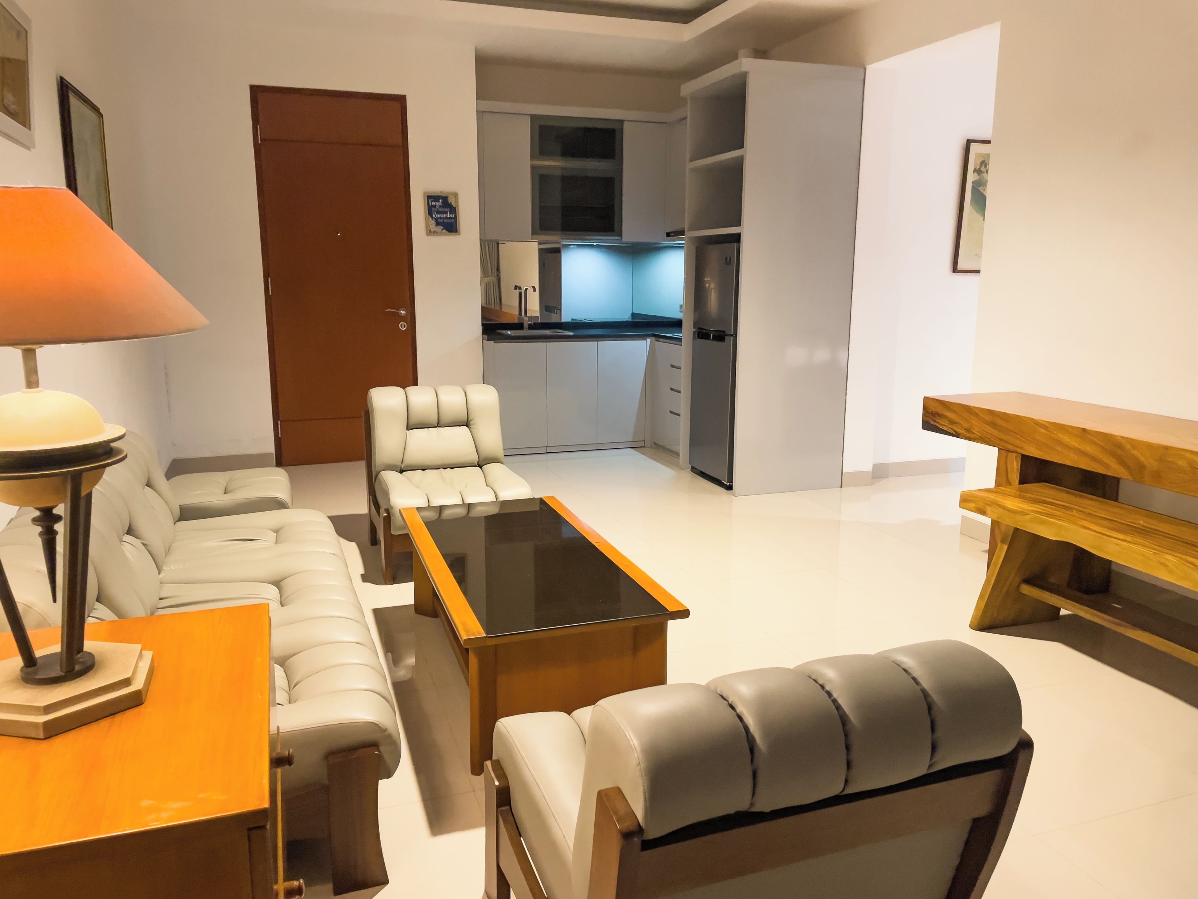 Uma sala de estar moderna com sofá, mesa de centro e um banco de madeira.