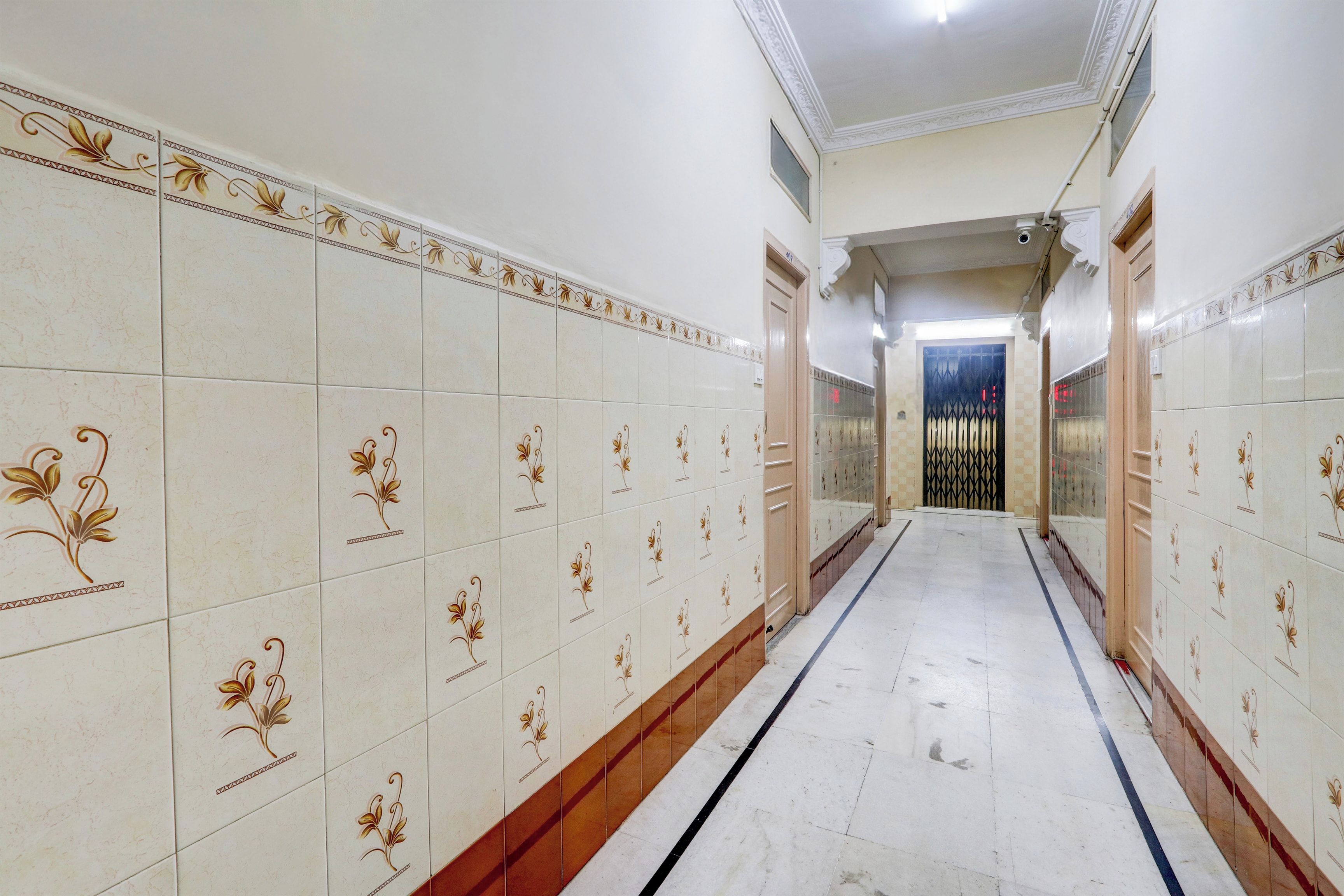 A corridor with patterned tiles and a door at the end.