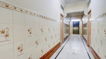 A corridor with patterned tiles and a door at the end.
