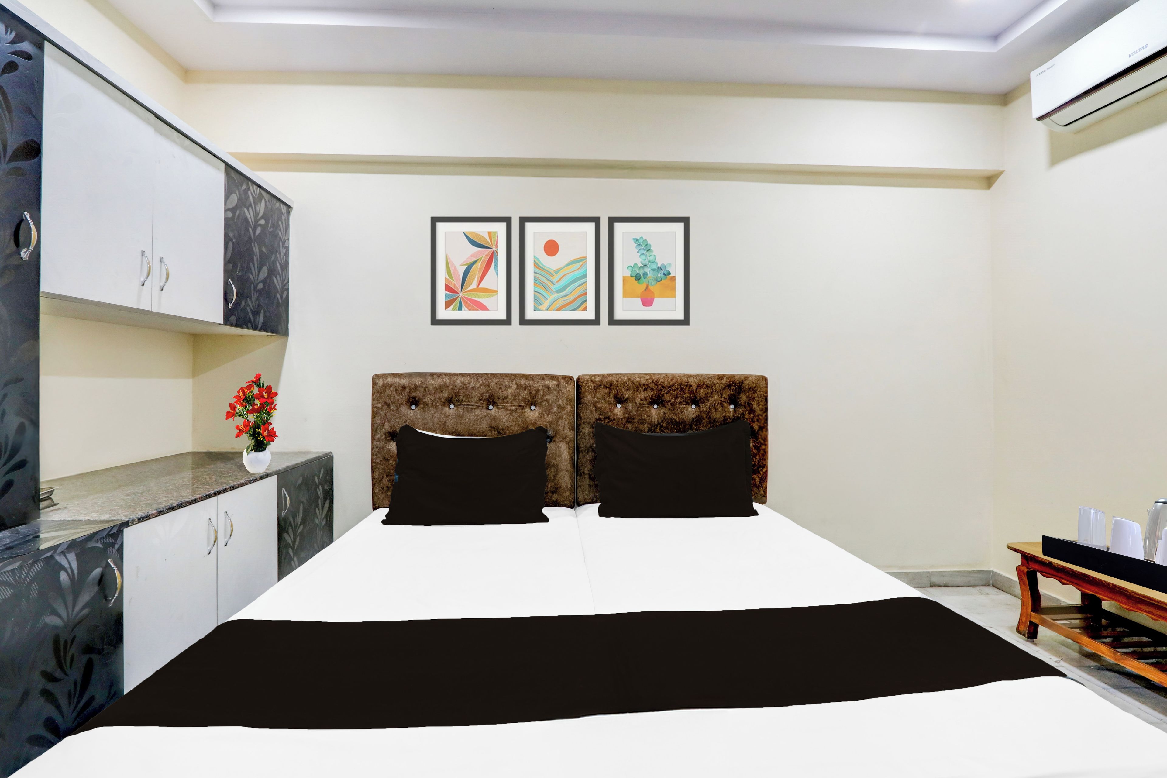 A bedroom with a bed, a nightstand, a dresser, and a wall-mounted air conditioner.