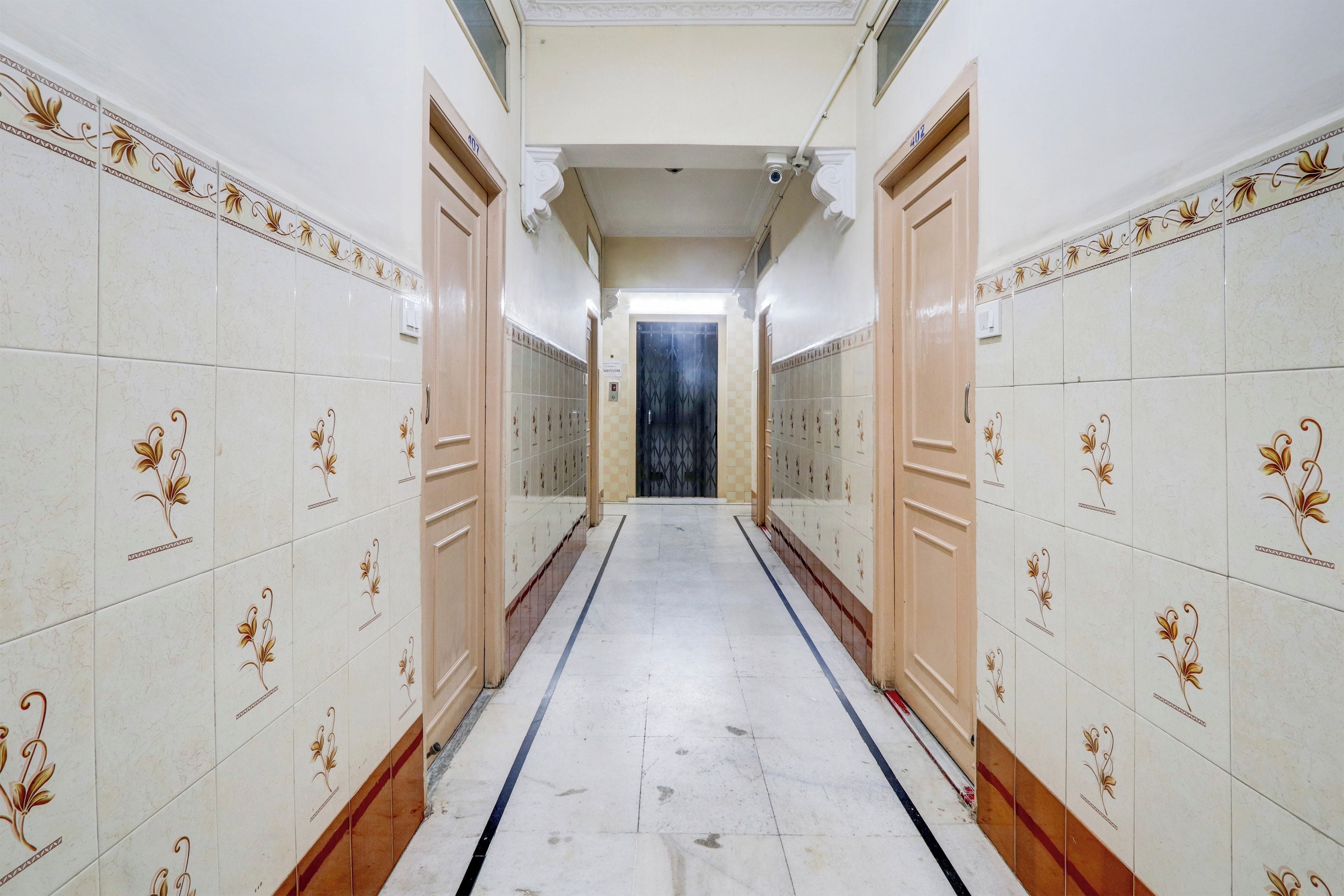 A corridor with tiled walls and a central walkway.