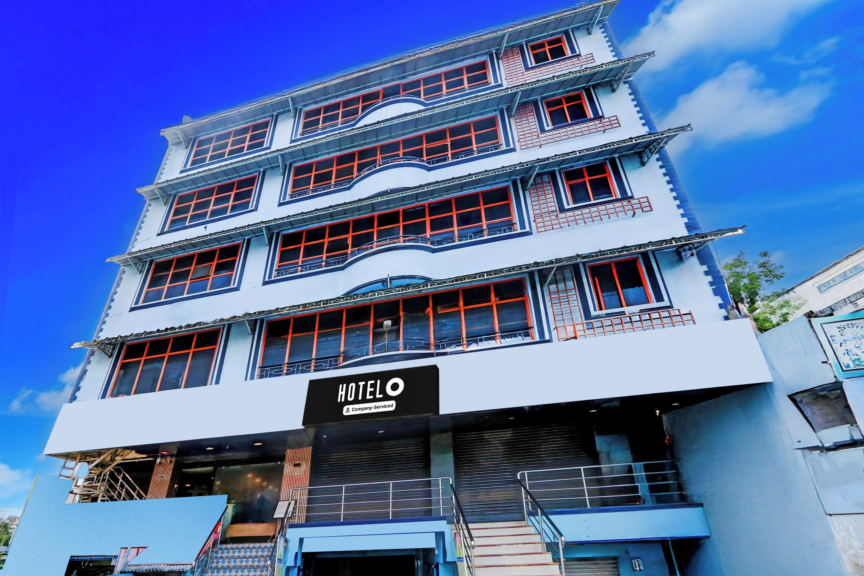 A multi-story hotel with a sign reading 'HOTELO Company Serviced'.