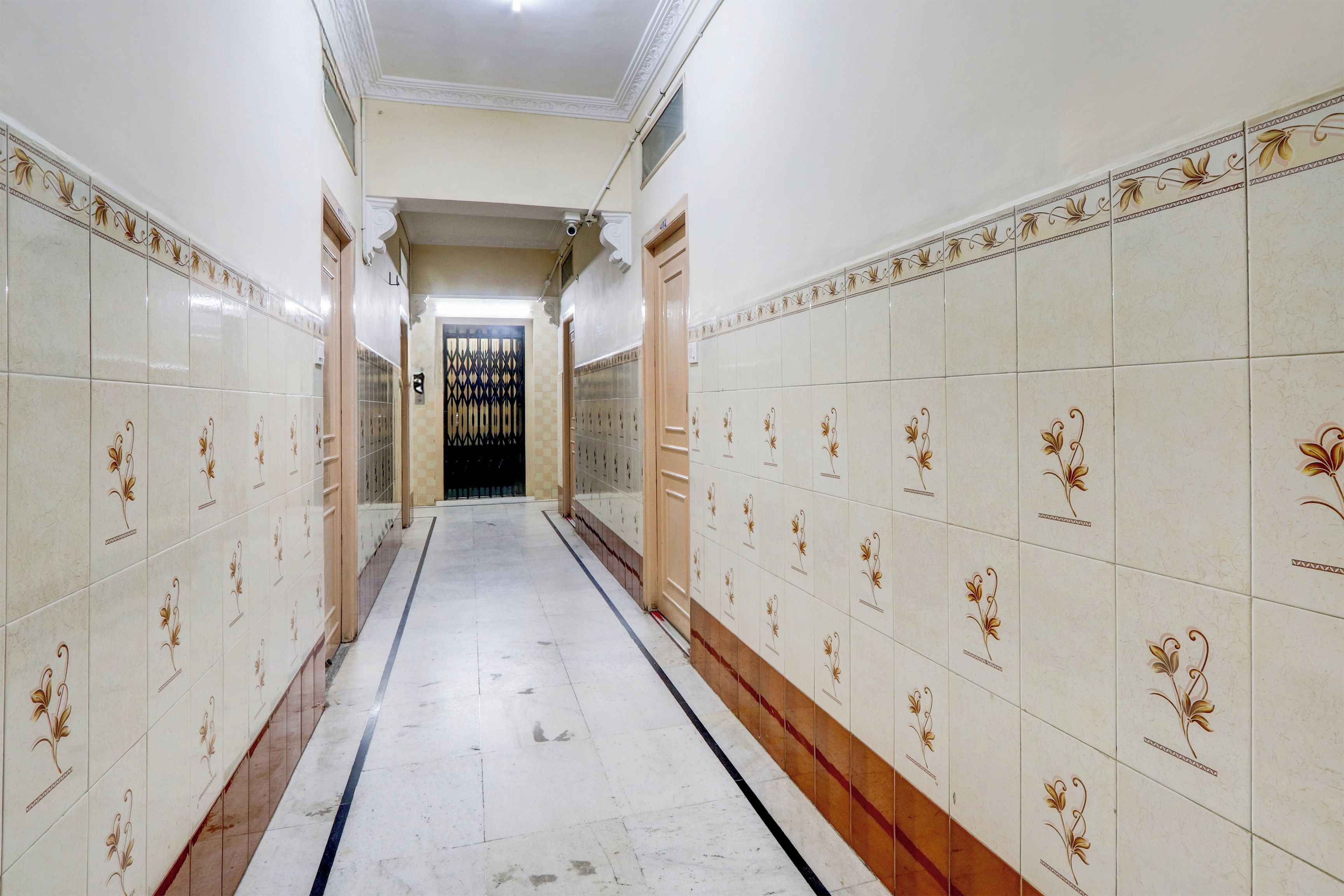 Un pasillo con paredes y piso de baldosas, que conduce a una puerta al final.