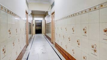 Un pasillo con paredes y piso de baldosas, que conduce a una puerta al final.