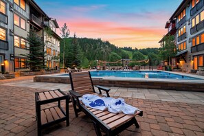 A pool area with lounge chairs and a view of a mountainous landscape. - Steps To Winter Park Gondola • Shared Hot Tub + Pool | Little Moose (Winter Park)