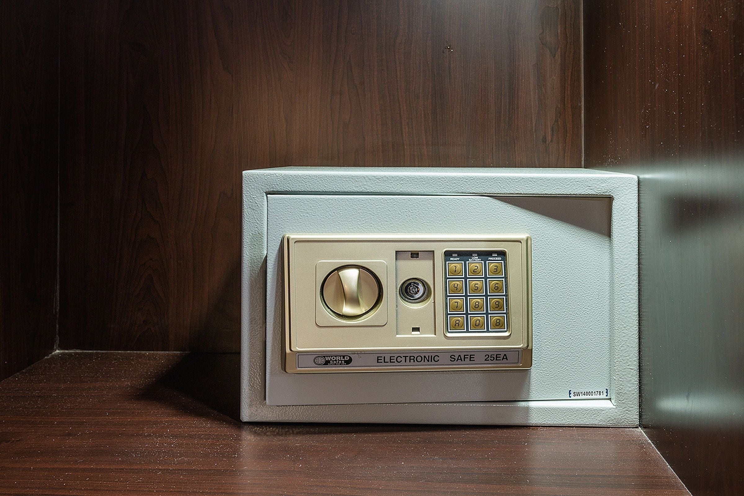 Een magnetron met een keypad en een draaiknop, gelabeld 'WORLD ELECTRONIC SAFE 25EA'.