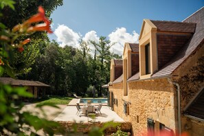 A stone building with a pool and outdoor seating. - Le Clos de Milhac (Milhac)