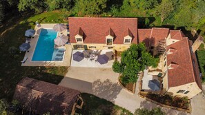 An aerial view of a property with a swimming pool, outdoor seating, and a large building with a red roof. - Le Clos de Milhac (Milhac)