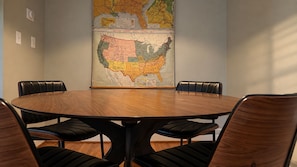 A conference room with a round table and six black leather chairs. A large map of the United States is displayed on the wall behind the table. - Renovated haymount home, less than 10 min from I-95 (Fayetteville)
