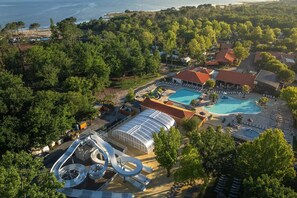 An aerial view of a resort with multiple swimming pools, a water slide, and a beach area. - PREMIUM 6-PERSON MOBILE HOME WITH 3 BEDROOMS AT 5-STAR MAYOTTE CAMPSITE—AIR CONDITIONING, FURNISHED, PARKING, LAKE ACCESS (Biscarrosse)