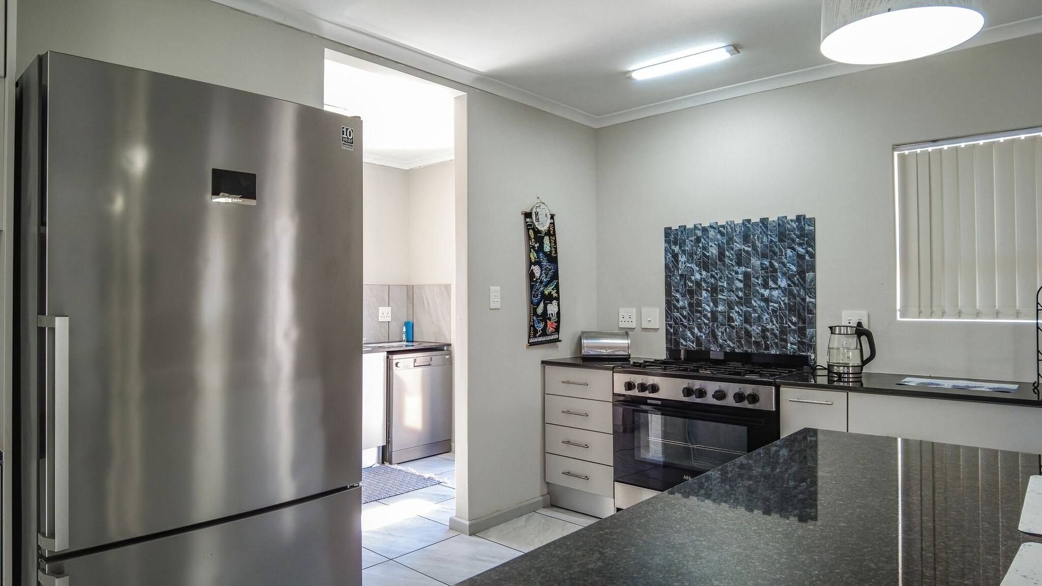 A modern kitchen with a stainless steel refrigerator, a stove, and a microwave.