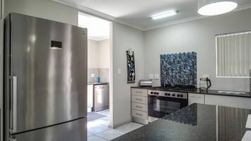 A modern kitchen with a stainless steel refrigerator, a stove, and a microwave.