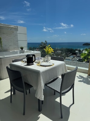 Ein Tisch für zwei Personen mit Blick auf das Meer, eine weiße Tischdecke und eine Kaffeekanne.