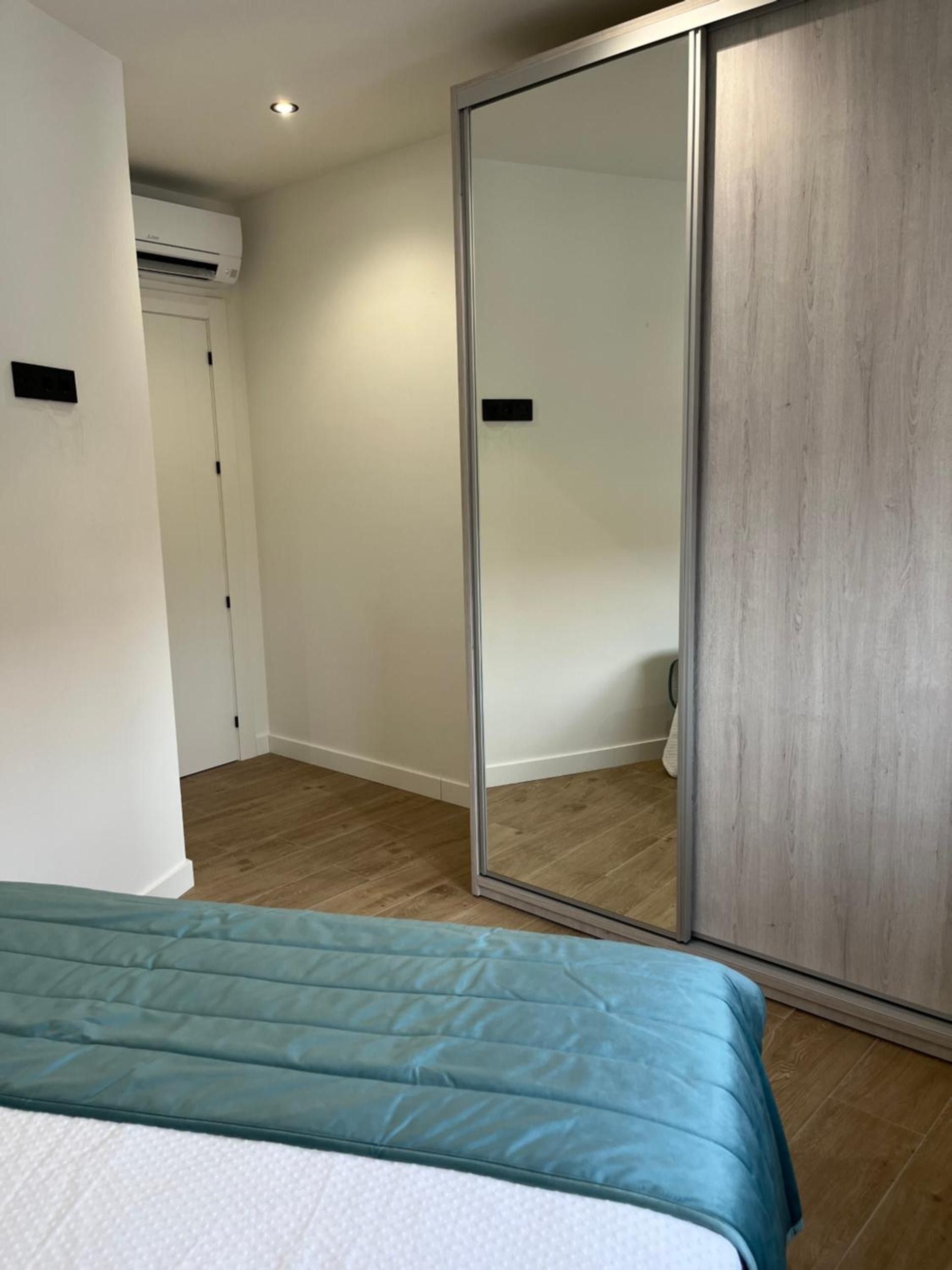 Ein Schlafzimmer mit einem Bett, einem Kleiderschrank und einer Klimaanlage.
