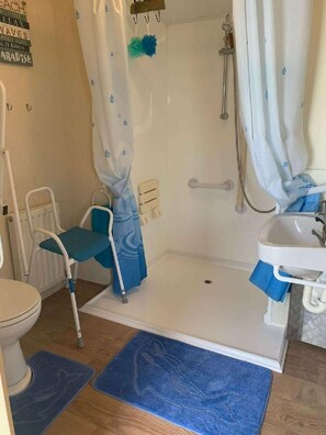 A bathroom with a shower, toilet, and sink. - Lyons Robin Hood - Holiday Accommodation 15838 (Rhyl)