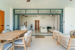 A modern interior with a dining area, a living room, and a kitchen. - 2BR Oceanfront Condo • Pool View • Sol de Arena C2 by Bocobay (Las Terrenas)
