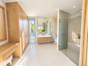 A modern bathroom with a wooden vanity, a glass shower enclosure, and a large mirror. - Brand New Private 3-Bedroom Pool Villa in Bang Tao, Phuket (Thep Krasatti)