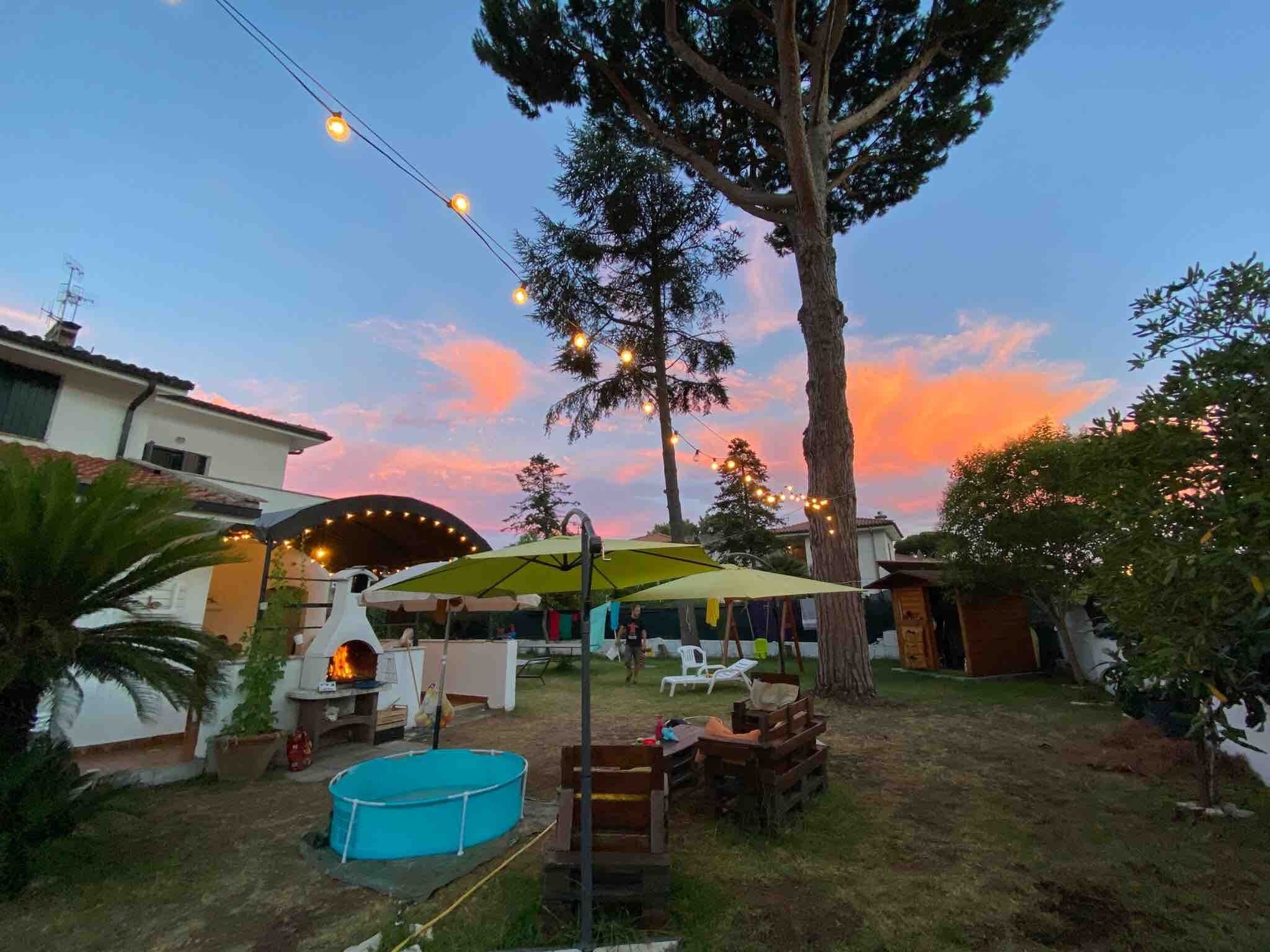 A backyard with a barbecue grill, a swimming pool, and string lights.