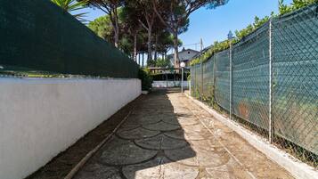 Un estrecho sendero con pavimento decorativo que lleva a una zona residencial.