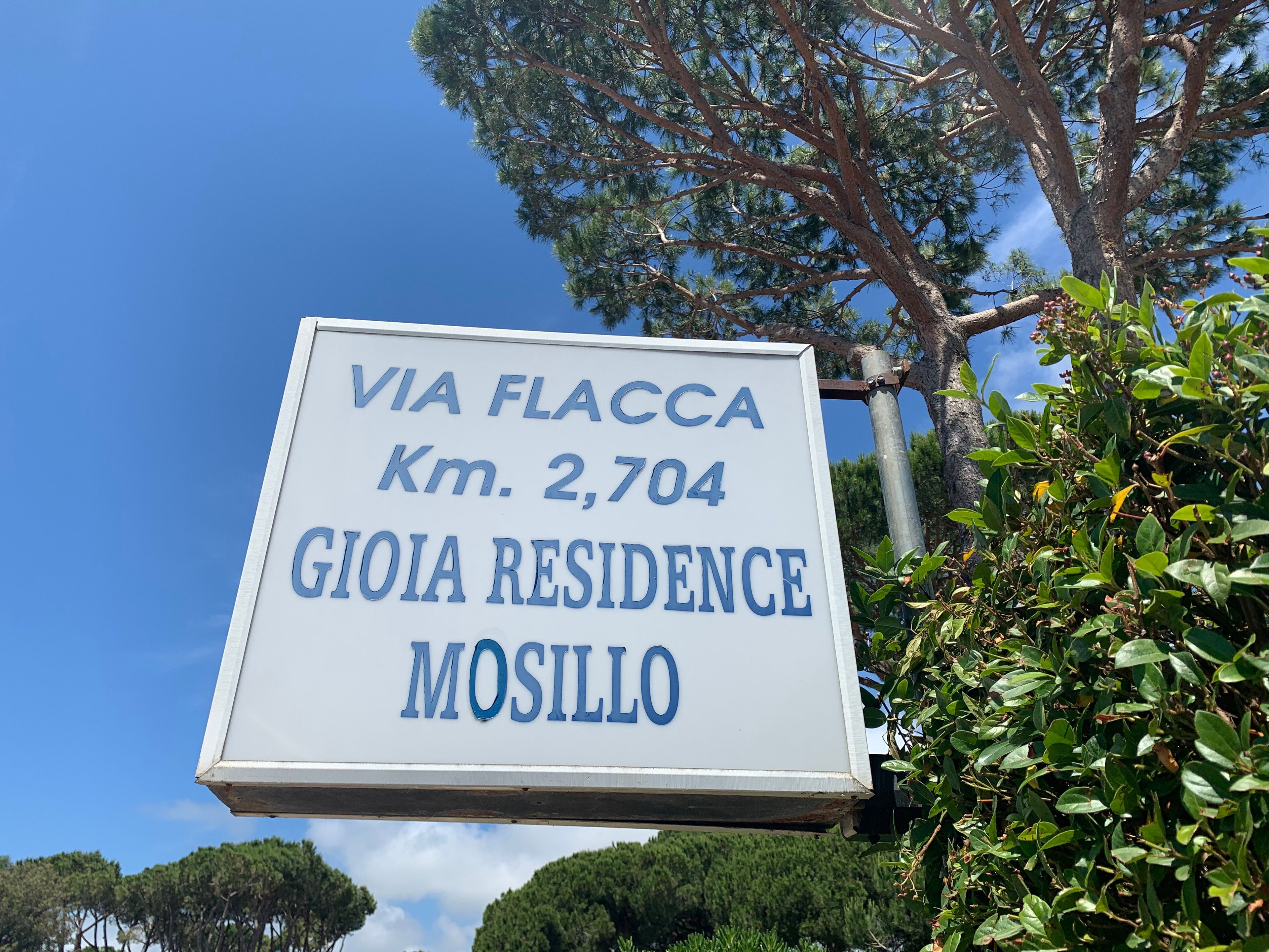 A sign indicating 'VIA FLACCA Km. 2,704 GIOIA RESIDENCE MOSILLO'.
